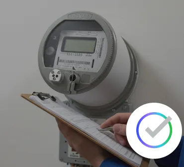 A large group of people dressed in white shirts with green designs and green caps pose together outdoors on a grassy field, surrounded by trees. Many are smiling and raising their hands in celebration or greeting.